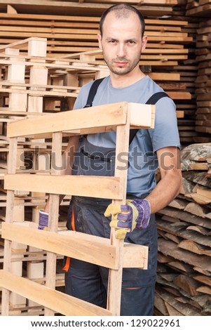 Warehouse worker moving wood pallets