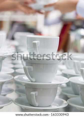 Lots of coffee cups with hands on background, vertical shot