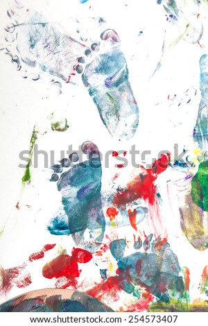 Colorful toddler\'s feet imprinted with paints on paper