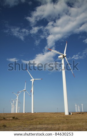 Wind power generators with blue sky background, vertical shot.