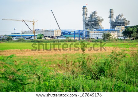 Construction of factory near by rice field at countryside of Thailand