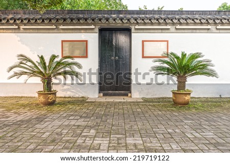 The traditional wooden door and concrete fence of old Chinese building in China