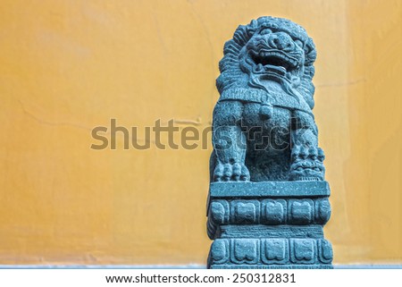 The art of Chinese lion stone sculpture isolated on yellow wall