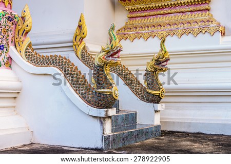 Vintage concrete guardian Thai Naga statues of old Thailand tale on stairway in temple