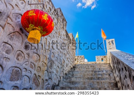 Vintage concrete stairway to top of wall with red fabric lantern in Chinese village, Mae Hong Son province, Northern Thailand