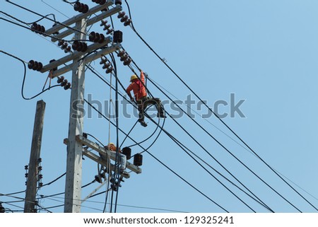 An electrical power utility worker fixes the power line.