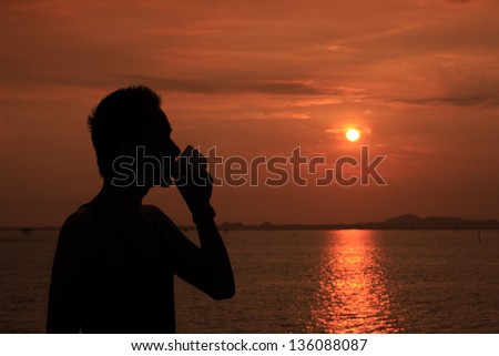 silhouette of relaxing man having coffee while sun rising