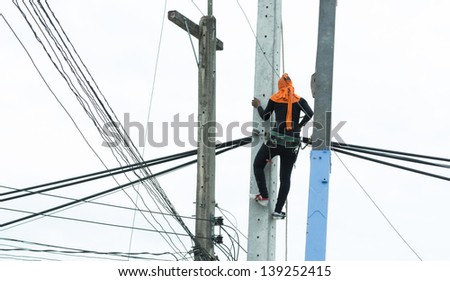 An electrical power utility worker fixes the power line