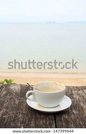 Coffee cup on grunge terrace facing seascape