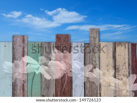 Butterfly and flower painted on vintage fence with blue sky background