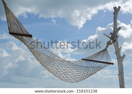 white hammock over blue sky white cloud background