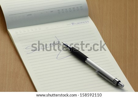 Pen and business plan notebook on wooden desk,succeed in bussiness concept