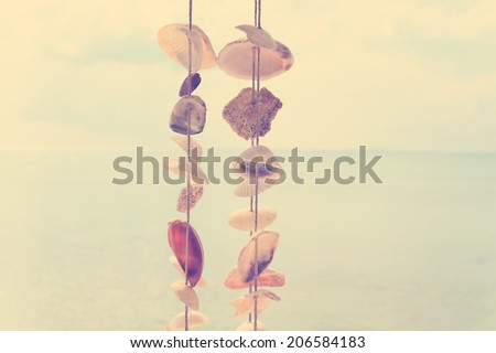 Wind bell shell mobile over ocean in vintage style