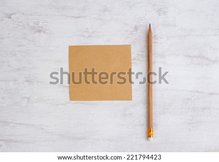 Recycled paper pad and pencil on white wooden background