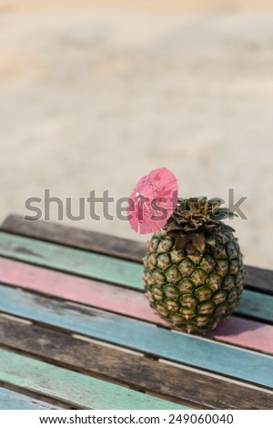 Pineapple fruit on vintage wood table with beach sand background