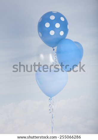 Blue balloons in heart shape and polka dot over blue sky background with retro filter effect