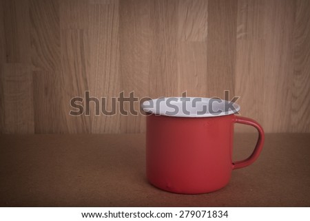 Vintage red mug on wood board background