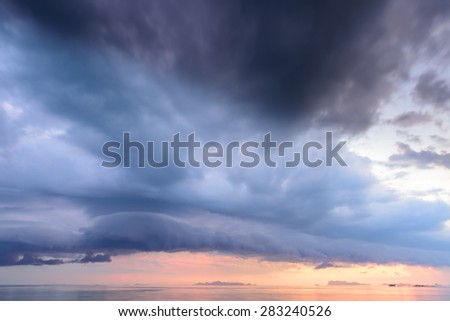 Dramatic tropical rain cloud sunset sky and sea at dusk background