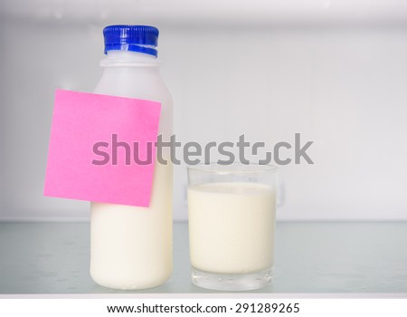 Bottle and glass of milk with postit  in refrigerator