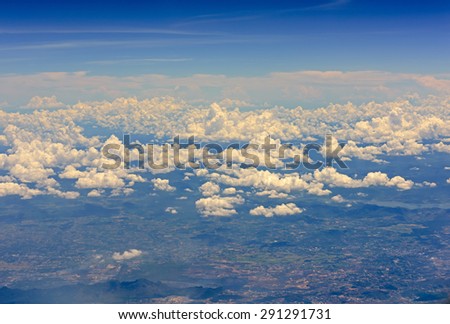 Aerial view from jet plane blue sky and big white cloud with green island background,out of focus