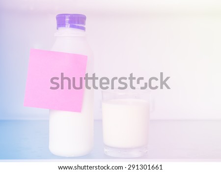 Bottle and glass of milk  in refrigerator with post it,retro filter effect
