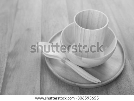 Black and white wood kitchen utensils over grunge wooden table background