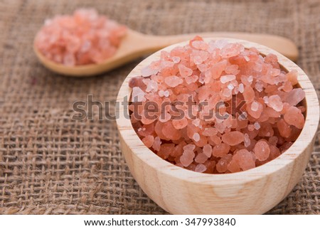 Himalayan raw salt in glass bottle on sack cloth background,spa health care concept