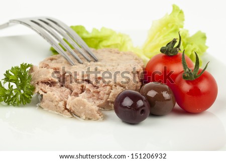 Canned tuna chunks with tomato cherries and olives