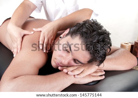 Masseur doing back massage on man body in the spa salon.