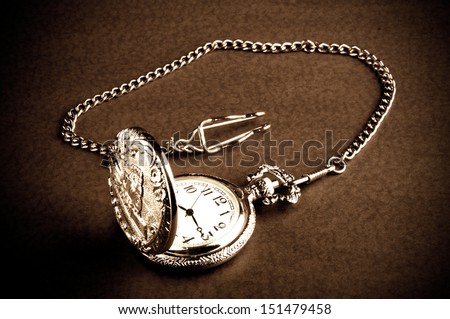 Old retro pocket watch with chain on table