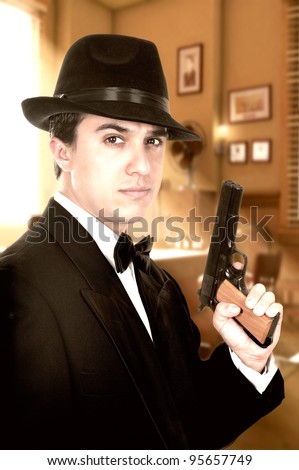 Man in suit draws vintage handgun, white collar outfit.