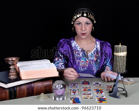 Gypsy fortune teller holding a tarot card