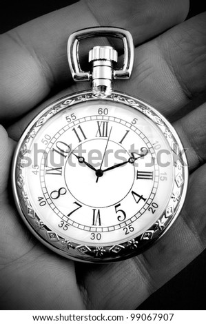 Pocket watch in senior man\'s hand - black and white