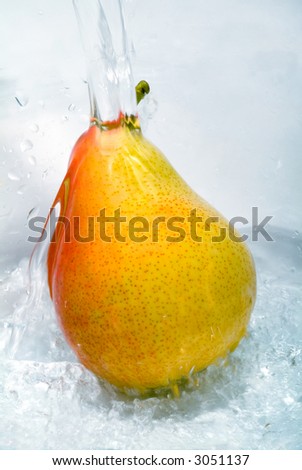 Fresh pear jumping into water with a splash