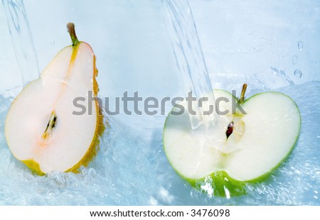 Fresh pear and apple jumping into water with a splash
