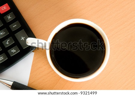 Coffee and business accessories on a table.