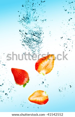 Strawberry are falling in water with a big splash