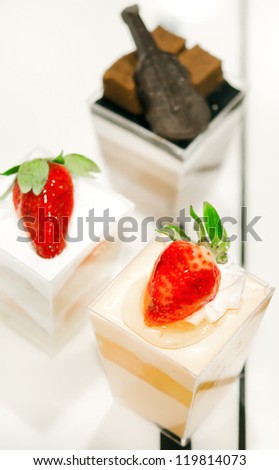cheese cake with  strawberries,  decorated with fresh strawberries and chocolate , served in a bowl with a small