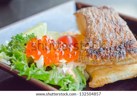 grilled cod fish  served with fresh salad with fish egg  on plate