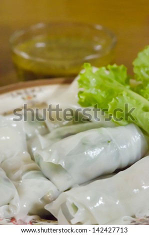 Chinese rice noodle roll served with lettuce and chili sauce