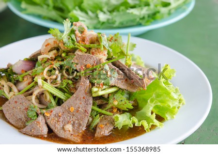 close up spicy sliced liver salad with fresh vegetable on dish , asian spicy food
