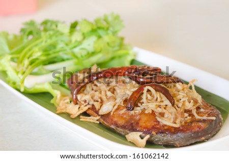 Fried pickled fish , onion  and chili served  with fresh vegetable on dish