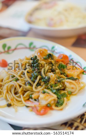 close up stir fried spicy spaghetti with shrimp and mix asian herbs , mix vegetable
