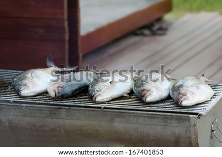 fish grill on grilling sticks , seafood Barbecue