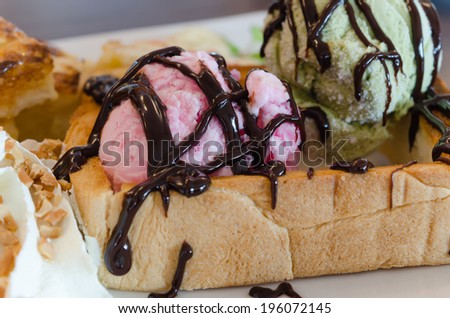 close up pink ice cream  with oney toast and whipping cream with chocolate  sauce