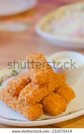 fresh fish fingers and white sauce on dish