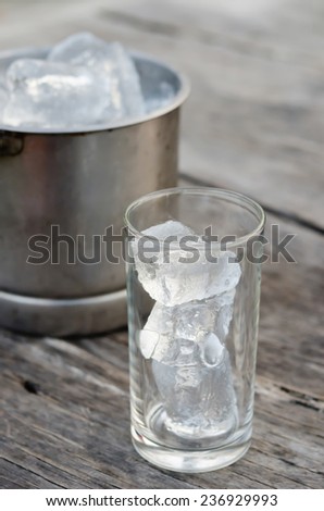 Glass with ice cubes and Ice bucket filled with ice cubes