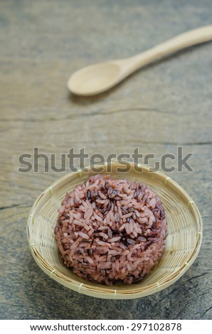 Cooked rice of Riceberry in bamboo basket  on wooden table