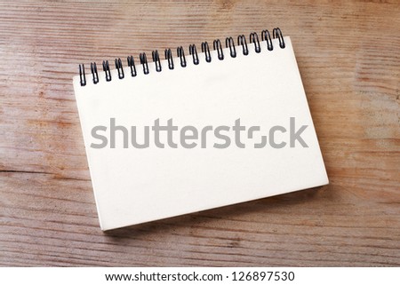 White notebook on wooden ground/notebook/paper
