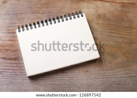 White notebook on wooden ground/notebook/paper